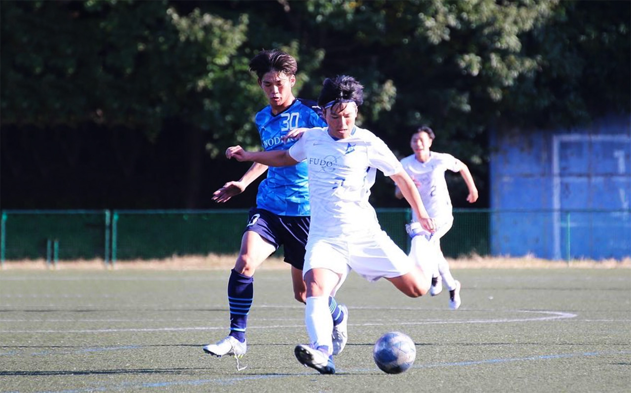 グラウンドでプレーする少年サッカー選手
